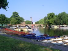 boats along a river with a bridge in the distance